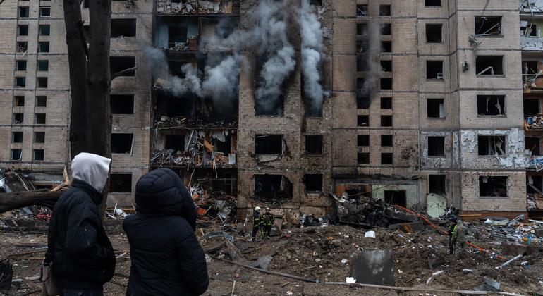 People walk passed a recently bombed building in Kyiv, Ukraine, in January 2024.