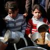 Niños de la Franja de Gaza esperan a que les sirvan comida.