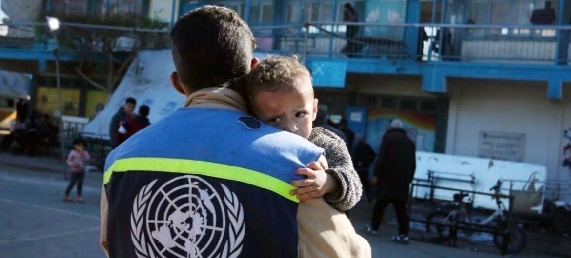 Un employé de l'UNRWA assiste un enfant à Gaza.