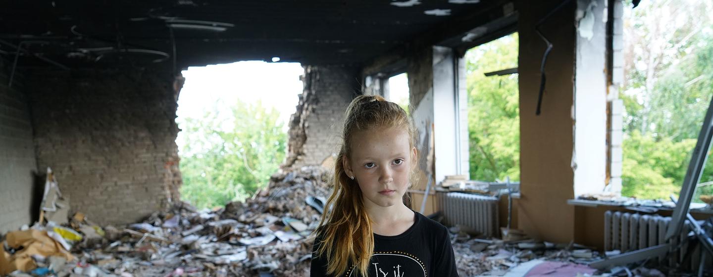 Anya, huit ans, au milieu des décombres de son école endommagée à Buzova, en Ukraine.