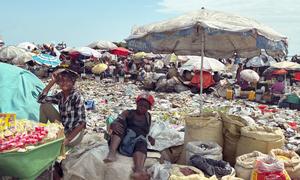 Vendors surrounded by garbage sell goods in Port-au-Prince, Haiti.