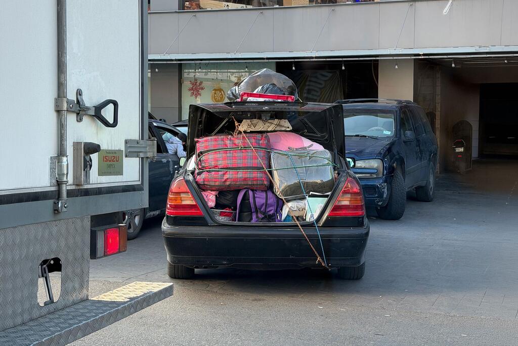 Une voiture chargée des biens de personnes déplacées par le conflit traverse une zone urbaine au Liban.