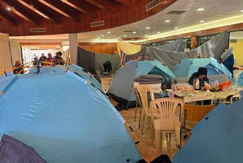 डब्ल्यूएचओ की टीम 9 मार्च, 2026 को लेबनान के बेरूत में डेकवानह तकनीकी संस्थान में कैरिटास लेबनान द्वारा संचालित नीले तम्बू और अंदर के लोगों के साथ अस्थायी आश्रय का निरीक्षण करती है।