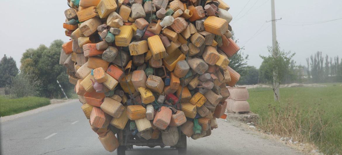 在阿富汗昆都士省，一辆三轮车装载着用过的塑料容器，正在前往回收厂。