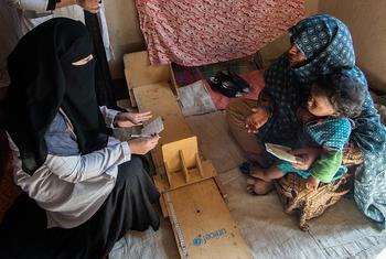 在阿富汗坎大哈的一个村庄里，流动诊所的护士为家庭提供营养援助。
