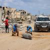 فريق من الأمم المتحدة يتفقد قنبلة غير منفجرة ملقاة على طريق رئيسي في خان يونس بغزة.