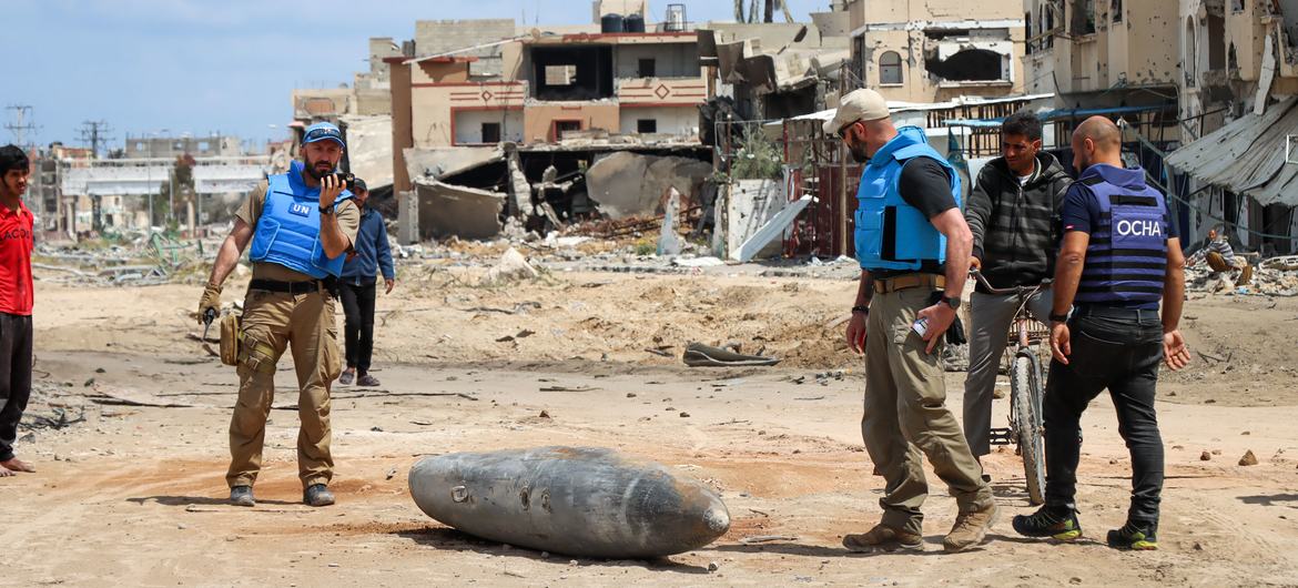 فريق من الأمم المتحدة يفحص قنبلة غير منفجرة تزن ألف رطل، في شارع رئيسي في خان يونس، جنوب قطاع غزة.