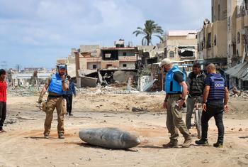 فريق من الأمم المتحدة يفحص قنبلة غير منفجرة تزن ألف رطل، في شارع رئيسي في خان يونس، جنوب قطاع غزة.