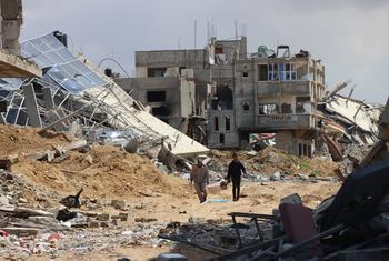 Deux personnes marchent au milieu de ruines à Khan Younis, dans la bande de Gaza.