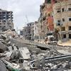 Widespread destruction in Khan Younis, Gaza Strip, showing damaged buildings and rubble on a street.