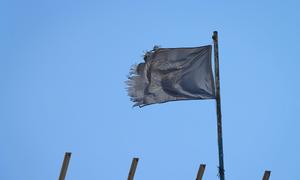 A shredded UN flag flies over a destroyed school building in Khan Younis, Gaza