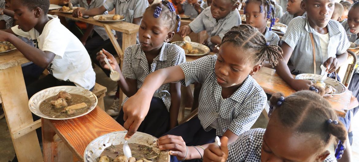 Des élèves mangent leur déjeuner à leur école dans le village de Belle Onde, dans le centre d'Haïti.