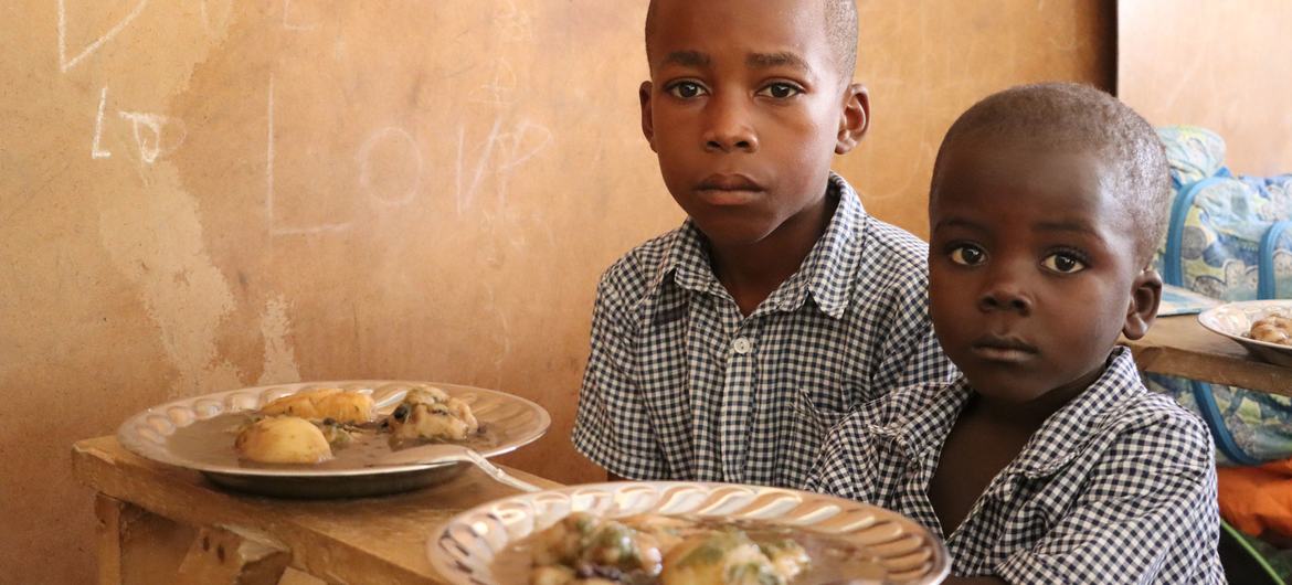 Primary school students in Haiti prepare to eat a lunch provided with the support of the United Nations.