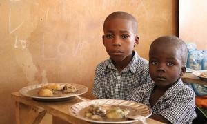 Primary school students in Haiti prepare to eat a lunch provided with the support of the United Nations.