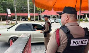 Police officers staff a checkpoint on Highway 1 in the north of Thailand.