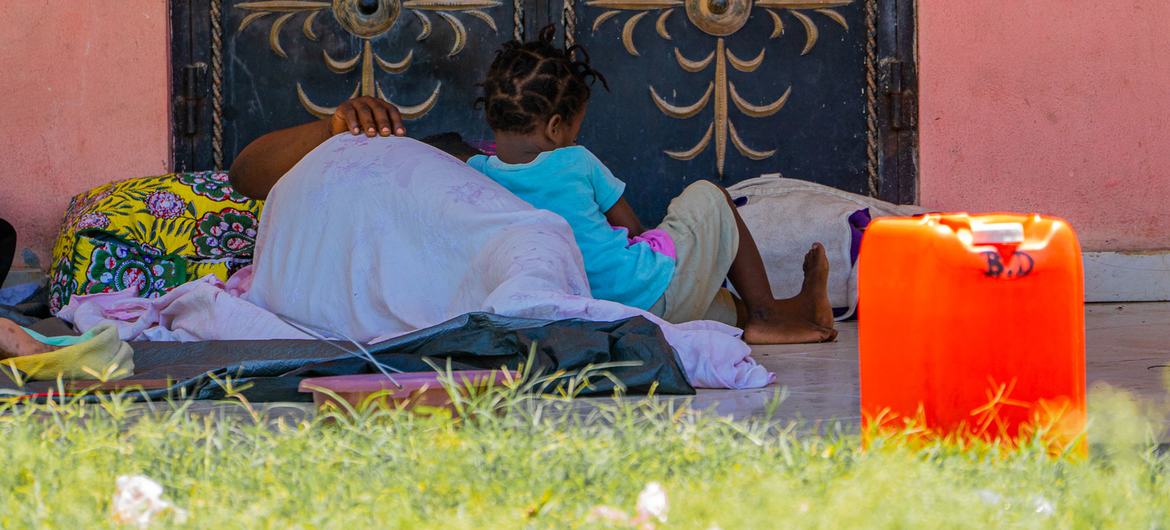 Une mère et son enfant, déplacés par la violence des gangs, dorment sur le sol dans une école, en Haïti.