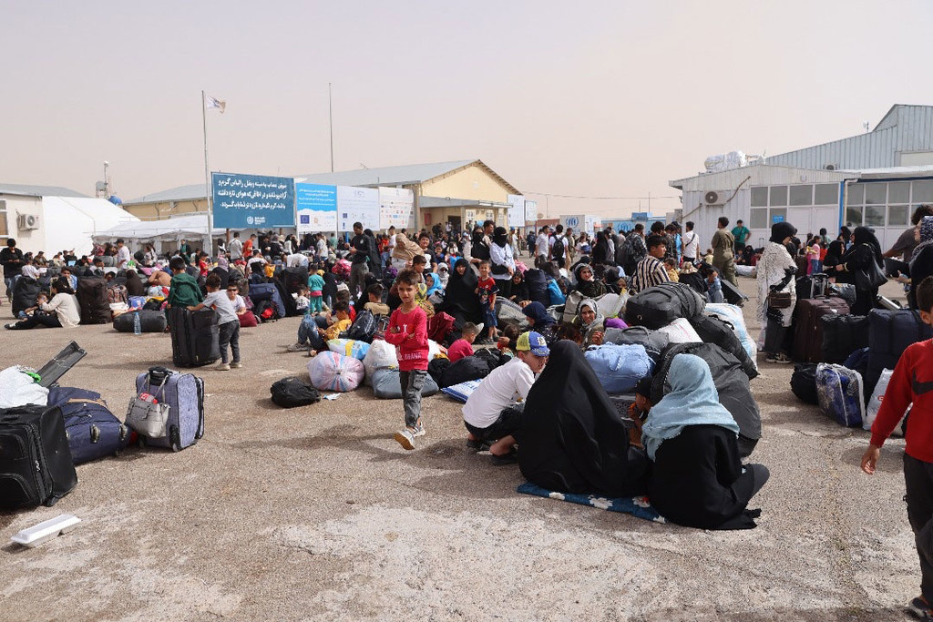 Afghan families who recently arrived from Iran gather at a border crossing in Herat Province, Afghanistan.