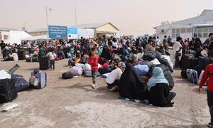Afghan families who recently arrived from Iran gather at a border crossing in Herat Province, Afghanistan.