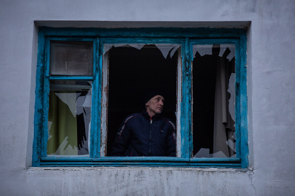 Un homme inspecte une fenêtre brisée dans une explosion à proximité de sa maison à Kherson, dans le sud de l'Ukraine.