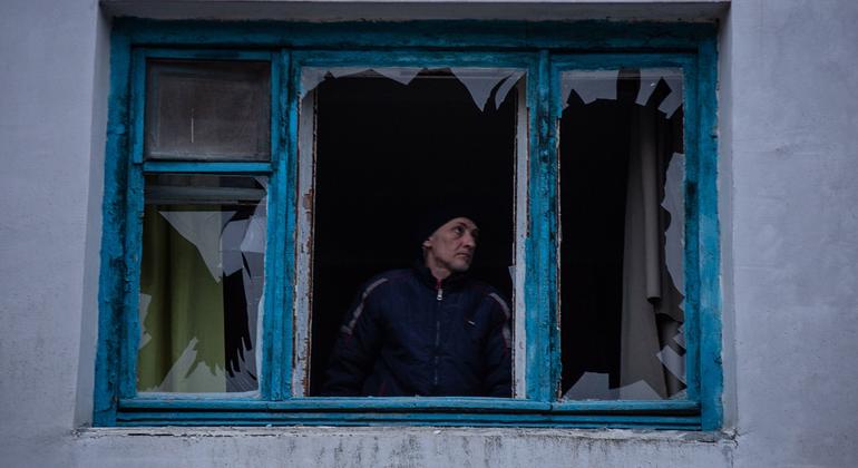 Un homme inspecte une fenêtre brisée dans une explosion à proximité de sa maison à Kherson, dans le sud de l'Ukraine.