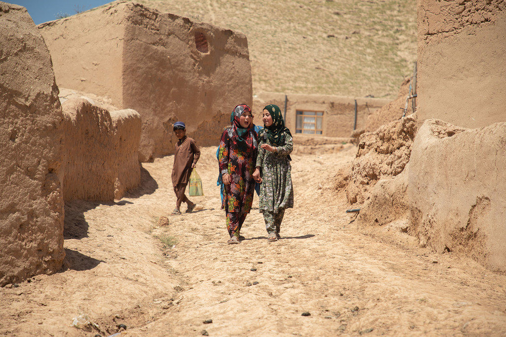 Deux jeunes filles afghanes marchent ensemble sur un chemin de terre dans le village de Shaikh Jalal, province de Baghlan, en Afghanistan.