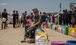 A child queues for water in Gaza.
