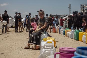 A child queues for water in Gaza.