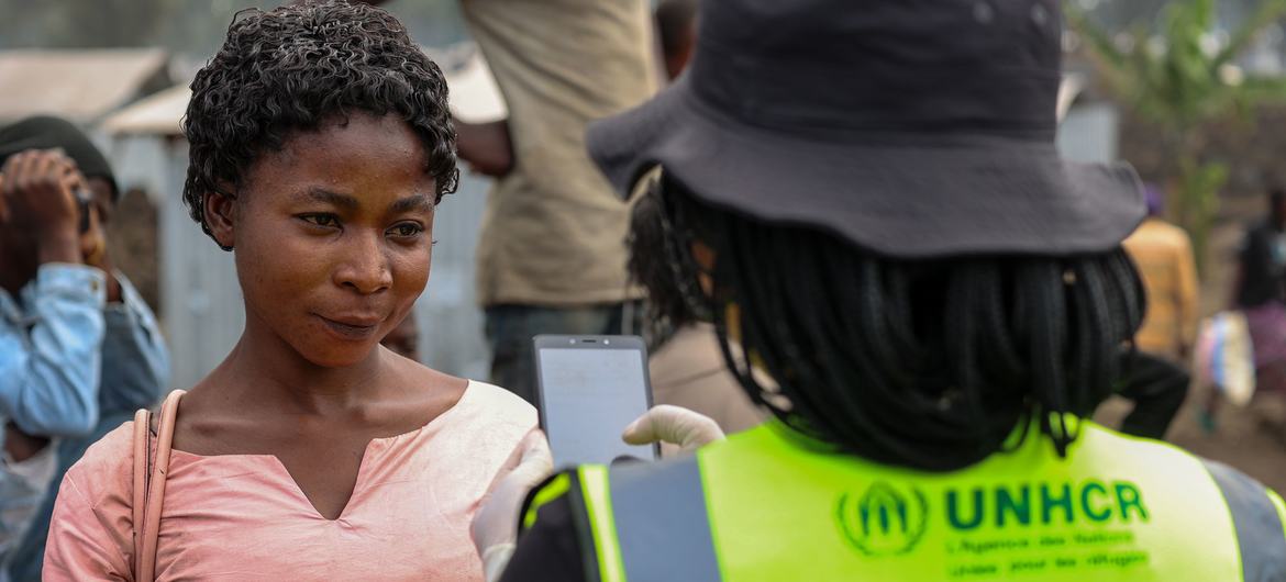 A UNHCR  member of staff discusses mpox with a woman in the Democratic Republic of the Congo. 