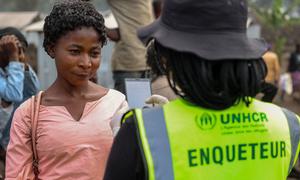 A UNHCR  member of staff discusses mpox with a woman in the Democratic Republic of the Congo. 