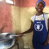 Une cuisinière prépare un repas chaud pour 300 élèves en Haïti.
