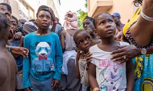 Children displaced by gang violence in Haiti wait in line for food.