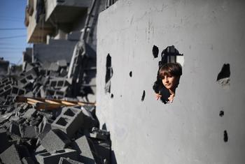 A 10- year-old boy looks through a hole in the wall of his house caused by an airstrike in Rafah, in the southern the Gaza Strip. (file)