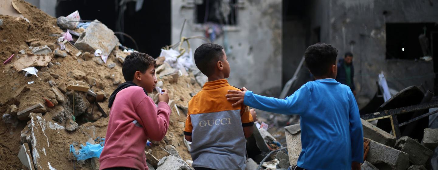 在加沙地带南部的拉法，孩子们看着被毁坏的家园。