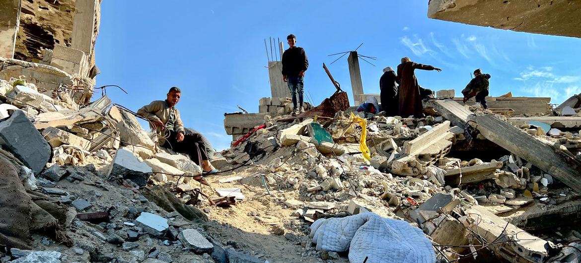 People walk on destroyed buildings in Gaza. 