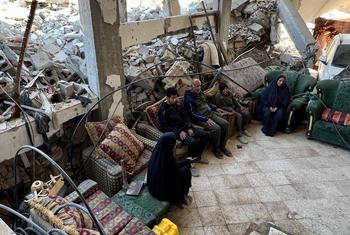 Jonathan Dumont, chef de la communication d'urgence du PAM, est assis avec des familles déplacées à l'intérieur d'une maison détruite à Gaza, entourée de décombres.