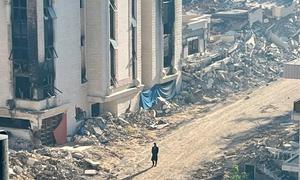 A person walks through a destroyed neighbourhood in Gaza.