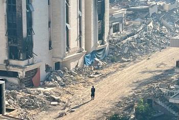 A person walks through a destroyed neighbourhood in Gaza.