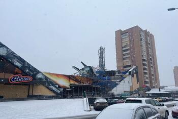 Barabara iliyofunikwa na theluji huko Saltivka, Kharkiv, Ukraine, ikionyesha majengo yaliyoharibiwa na sinema iliyoharibiwa kwa sehemu baada ya mashambulizi. UNHCR inatoa msaada wa dharura kwa jamii zilizoathiriwa.