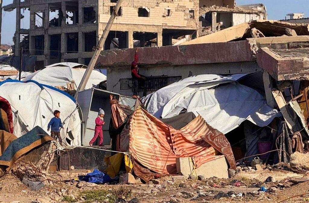 Des Palestiniens déplacés vivent dans des tentes improvisées au milieu des décombres et des bâtiments détruits le long de la plage de Gaza.