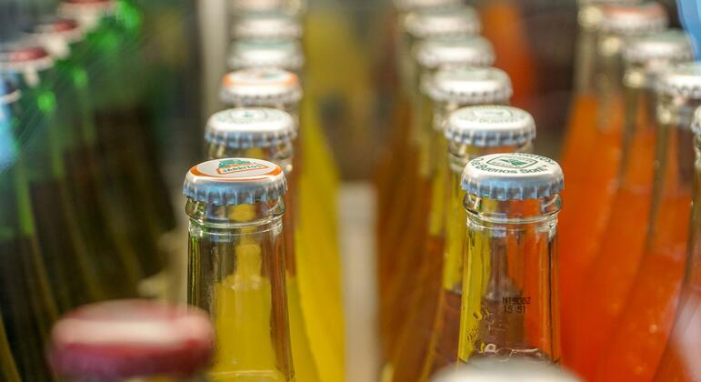 Des rangées de boissons sucrées sont exposées dans un supermarché.