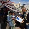 Люди, бежавшие в Рафах, получают гуманитарную помощь.