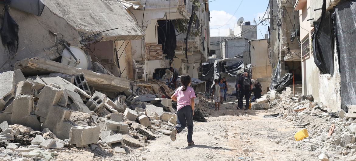 A young girl runs through the rubble of damaged buildings after an Israeli military raid at Nur Shams refugee camp, in the West Bank in August 2024. 