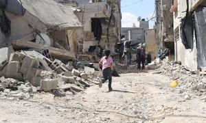 A young girl runs through the rubble of damaged buildings after an Israeli military raid at Nur Shams refugee camp, in the West Bank in August 2024. 