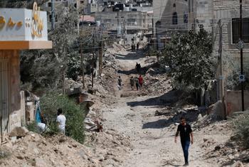 Des gens marchent à travers les décombres de routes et de bâtiments détruits dans le camp de réfugiés de Jénine, dans le nord de la Cisjordanie.