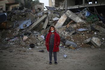 A twelve-year-old girl stands in front of her destroyed house in Rafah city, southern Gaza.