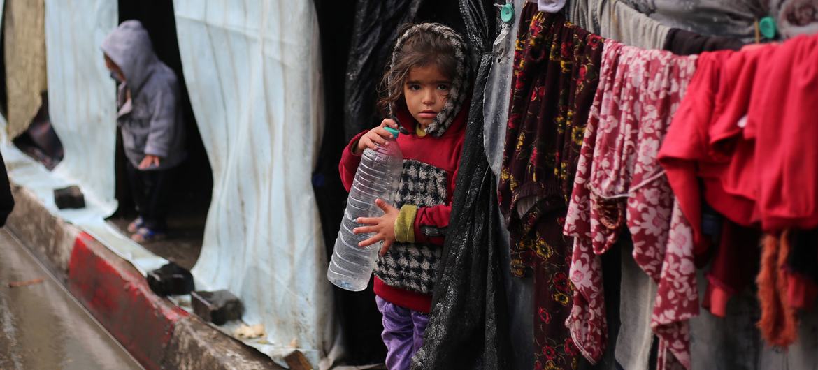Menina em frente ao seu abrigo na cidade de Rafah, em Gaza