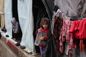 在加沙最南端的拉法，一个小女孩站在她家的帐篷前。