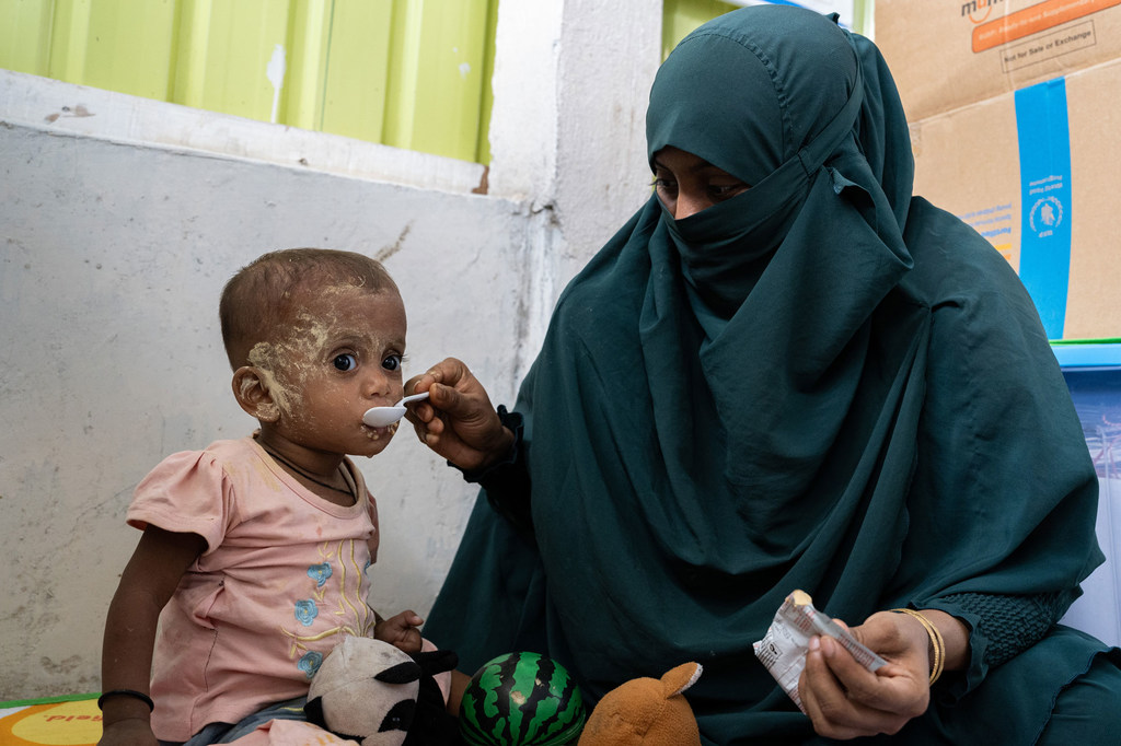 A child diagnosed with severe acute malnutrition is fed prepared therapeutic food by his mother at a refugee nutrition facility in Cox's Bazar, Bangladesh.