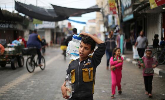 Un niño transporta agua por las calles de Gaza.
