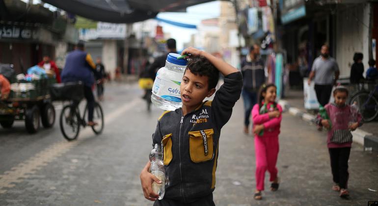 Un niño transporta agua por las calles de Gaza.